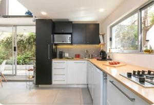 Una cocina con gabinetes negros y encimeras blancas. en Modern designer loft with solar, en Honeydew