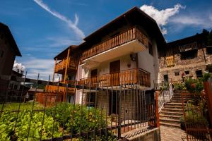 a house with a porch and a fence in front of it at Il Bosco dei 100 Acri in Roncobello