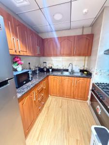 a kitchen with wooden cabinets and a sink at Full seaview luxury with gym,pool,jacuzzi,sauna,24x7 cafe,beach,restaurants,medical and more in Ajman 