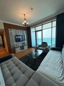 a large living room with a couch and a table at Full seaview luxury with gym,pool,jacuzzi,sauna,24x7 cafe,beach,restaurants,medical and more in Ajman 