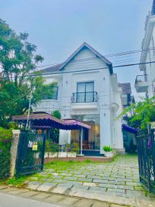 a white house with a gate in front of it at Khách sạn LiLac Đà Lạt in Da Lat