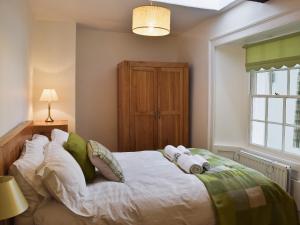 a bedroom with a large white bed with pillows at Acorn Lodge Cottage in Keswick
