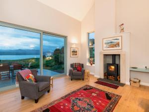 a living room with a fireplace and a large window at Tigh An Iasgair in Fearnmore