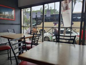 a restaurant with tables and chairs and a view of a street at Riviera Hotel Durban in Durban