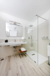 a white bathroom with a sink and a shower at Fuorlovado 40 in Capri
