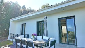 a dining table and chairs on a balcony at Villa Vacacional Las Encinas in Cuerres
