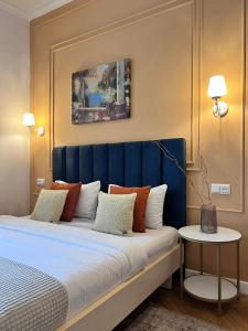 a bed with a blue headboard in a room at Siesta apartment on Stefanyka in Lviv