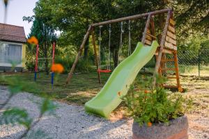 einen Spielplatz mit einer grünen Rutsche im Hof in der Unterkunft Family friendly house with a swimming pool Tounj, Gorski kotar - 17577 in Tounj