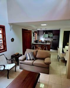 ein Wohnzimmer mit Couch und Küche in der Unterkunft Apartamento duplex em Praia do Forte - 2 suítes in Praia do Forte