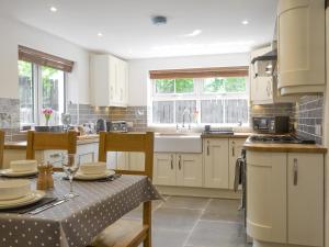 a kitchen with white cabinets and a table with glasses on it at Bryn Salem in Mallwyd