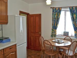 SwanwickにあるThe Coach Houseのテーブルと白い冷蔵庫のあるキッチン
