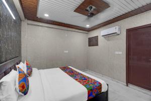 a bedroom with a bed and a ceiling fan at FabHotel Vrishti Residency in Greater Noida