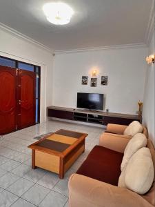 a living room with two couches and a flat screen tv at B&C Homestay in Miri