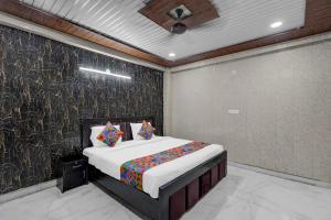 a bedroom with a bed and a wall at FabHotel Vrishti Residency in Greater Noida +16 photos
