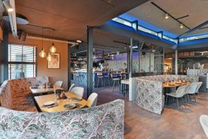 a restaurant with tables and chairs and a bar at Dock Hotel Stellendam in Stellendam