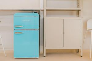 ein blauer Kühlschrank neben einem Bett in der Unterkunft 7BR House for 14 Guests with Big Terrace - Bonita Paradise in Guía de Isora