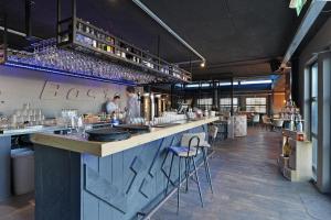 a bar in a restaurant with people standing at it at Dock Hotel Stellendam in Stellendam