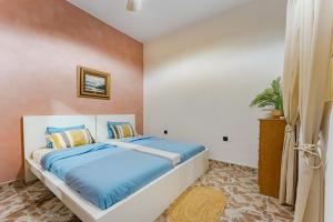 Schlafzimmer mit einem Bett mit blauer Bettwäsche in der Unterkunft 7BR House for 14 Guests with Big Terrace - Bonita Paradise in Guía de Isora + 32 Fotos