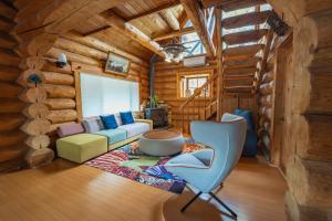 a living room with a couch and a chair at Hakuba Riverside Loghouse in Hakuba +80 photos