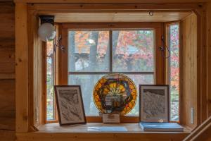 a window in a room with a stained glass window at Hakuba Riverside Loghouse in Hakuba