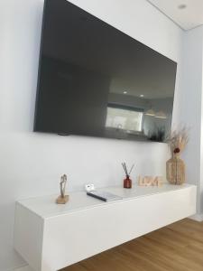 una mensola bianca con un televisore su un muro di Sun Temple by Madeira Holiday Rentals a Ribeira Brava