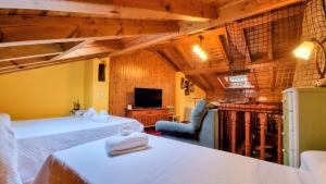 a hotel room with two beds and a television at Villa El Retiro Un Alojamiento con Encanto in Mediavilla