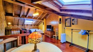 a room with a bed and a table with a lamp at Villa El Retiro Un Alojamiento con Encanto in Mediavilla