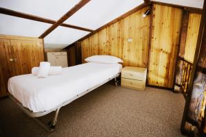 ein Schlafzimmer mit einem Bett in einem Zimmer mit Holzwänden in der Unterkunft Rifugio di Famiglia a due minuti dalle piste - Parcheggio e Wifi Gratuito in Sauze d'Oulx