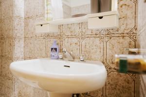 ein Badezimmer mit einem weißen Waschbecken und einem Spiegel in der Unterkunft Rifugio di Famiglia a due minuti dalle piste - Parcheggio e Wifi Gratuito in Sauze d'Oulx + 18 Fotos