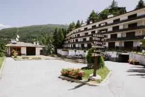 ein Straßenschild vor einem Gebäude in der Unterkunft Rifugio di Famiglia a due minuti dalle piste - Parcheggio e Wifi Gratuito in Sauze d'Oulx