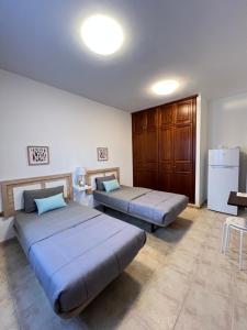 a bedroom with two beds and a refrigerator at Villa Petra in Tuineje