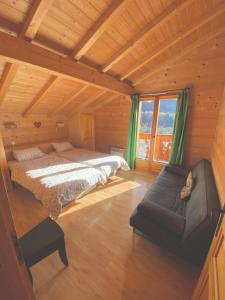 een slaapkamer met 2 bedden en een bank in een hut bij Chalet La Rose in Montriond