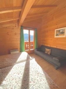 een slaapkamer met een bed en een groot raam bij Chalet La Rose in Montriond