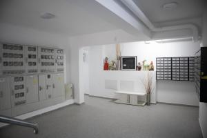 a white room with a bench and a tv on a wall at Garsonieră Studio in Dudu