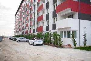 a parking lot with cars parked in front of a building at Garsonieră Studio in Dudu