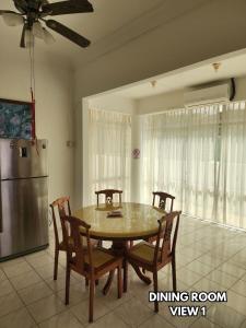 a dining room with a table and chairs and a refrigerator at B&C Homestay in Miri