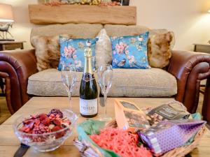 a table with two wine glasses and a bottle of wine at Farriers Lodge in Burshill