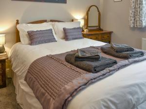 a bedroom with a large bed with towels on it at Lavender Cottage Was Fellside in Melmerby