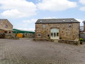 a large brick building with a white door at Westwood Barn in Brough Sowerby