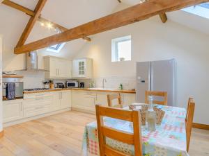 a kitchen with a table and chairs and a refrigerator at Westwood Barn in Brough Sowerby