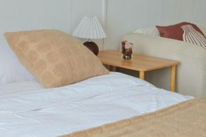 a bed with a pillow and a table with a lamp at Youshine Service Apart-ment ---English Speaking in Chengdu