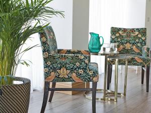 a room with a chair and a table with a vase at The Cart House in Duns