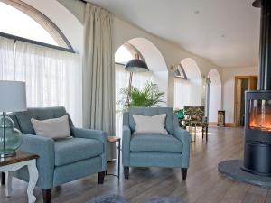 a living room with two chairs and a tv at The Cart House in Duns
