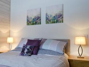 a bedroom with a bed with two paintings on the wall at Cruachan in Etteridge +7 photos