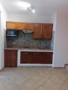 una cocina vacía con armarios de madera y fregadero en Beautiful condo a few steps to sea, en Cancún