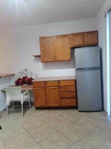 Una cocina con refrigerador blanco y gabinetes de madera. en Beautiful condo a few steps to sea, en Cancún