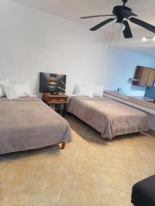 2 camas en una habitación con ventilador de techo en Beautiful condo a few steps to sea, en Cancún