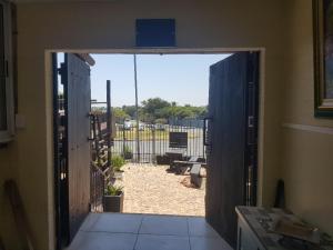 an open door with a view of a yard at 4th On Boundary in Gordonʼs Bay