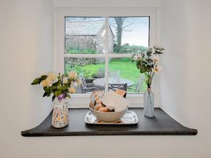 a table with a bowl of food and a window at Appleloft in Crackington Haven