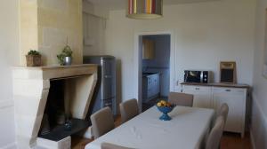 une cuisine avec une table et une cuisine avec une cheminée dans l'établissement Gîte Avec Piscine La Petite Gironde, à Porchères